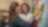 Două femei colege discută într-un birou modern. Una dintre femei scrie pe un post-it lipit pe un perete de sticlă, în timp ce cealaltă femeie zâmbește aprobator și citește.