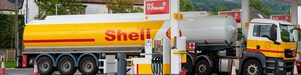 Cisternă Shell care alimentează la o stație de alimentare situată într-o zonă rurală plină de verdeață