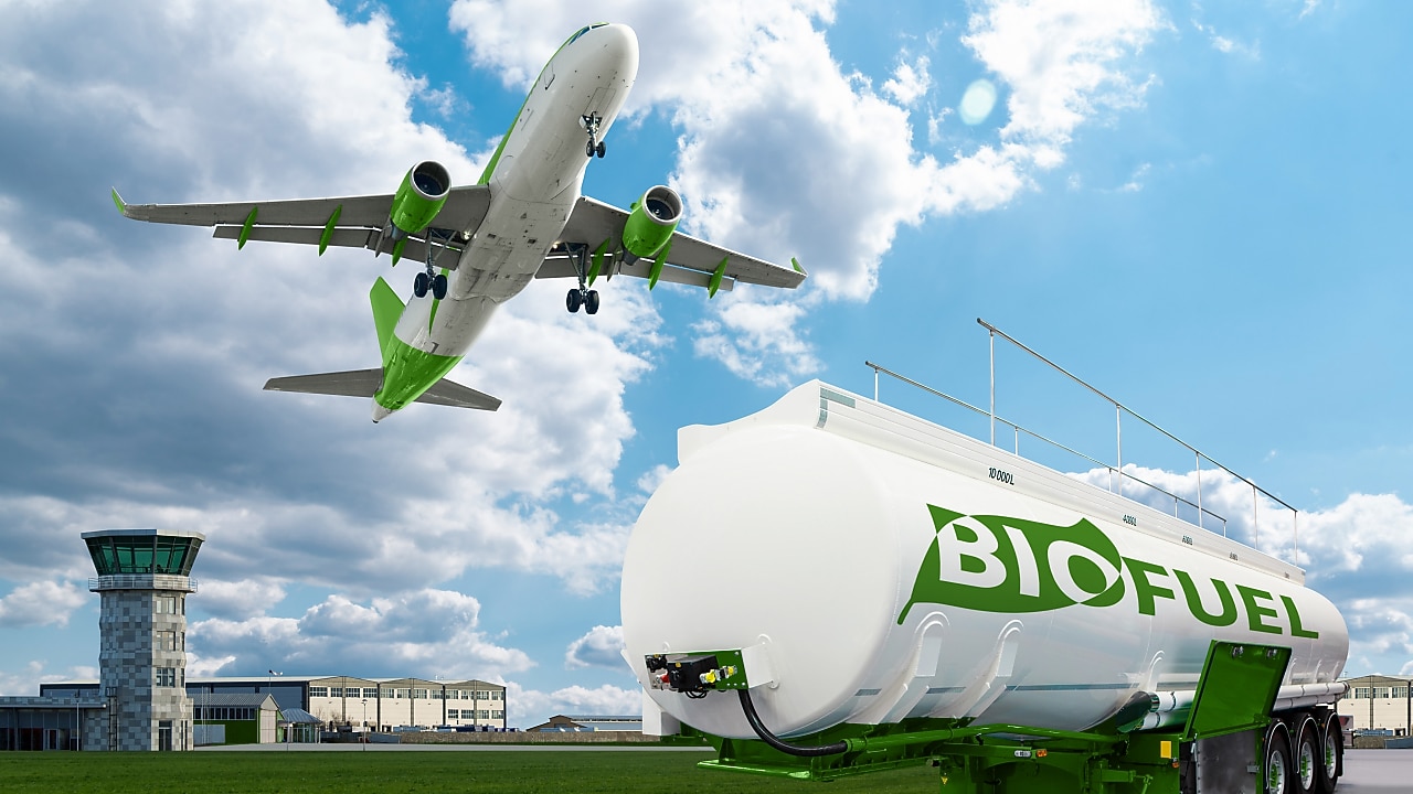 Cisternă albă pe care scrie Biofuel și un turn de control aerian în plan secund