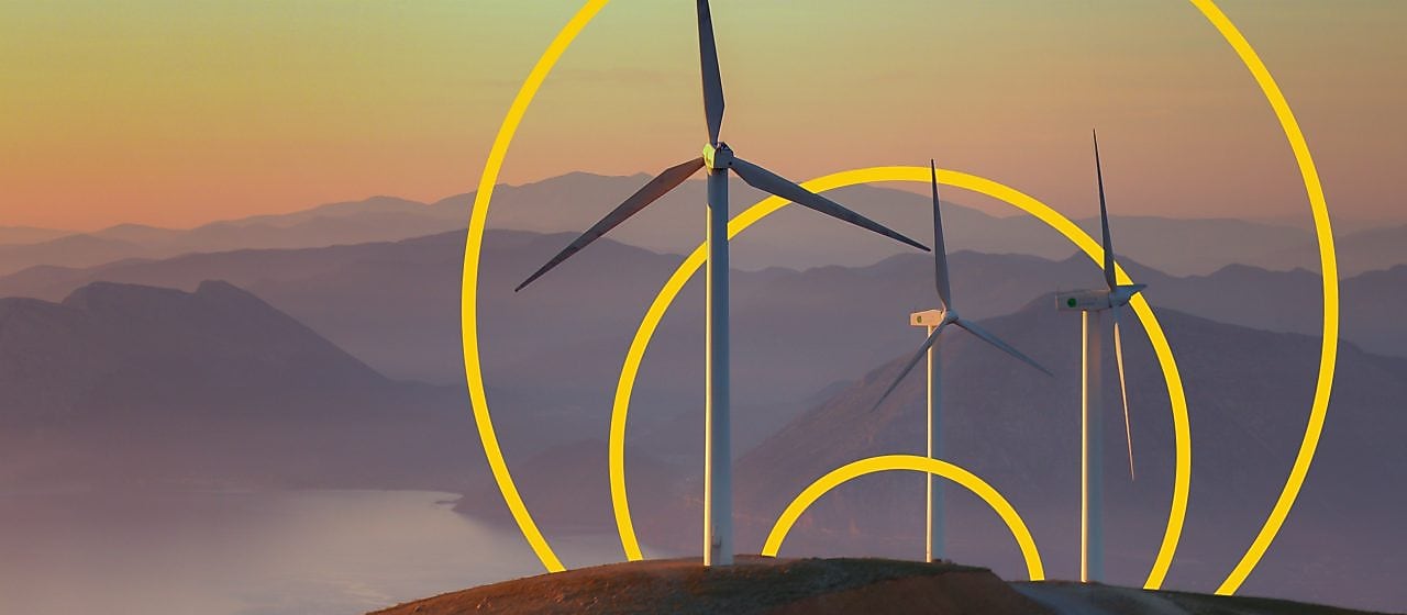 Fotografie cu trei turbine eoliene pe un deal, cu schița desenului Atingerea obiectivului de zero emisii nete