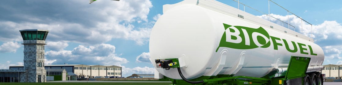 Cisternă albă pe care scrie Biofuel și un turn de control aerian în plan secund