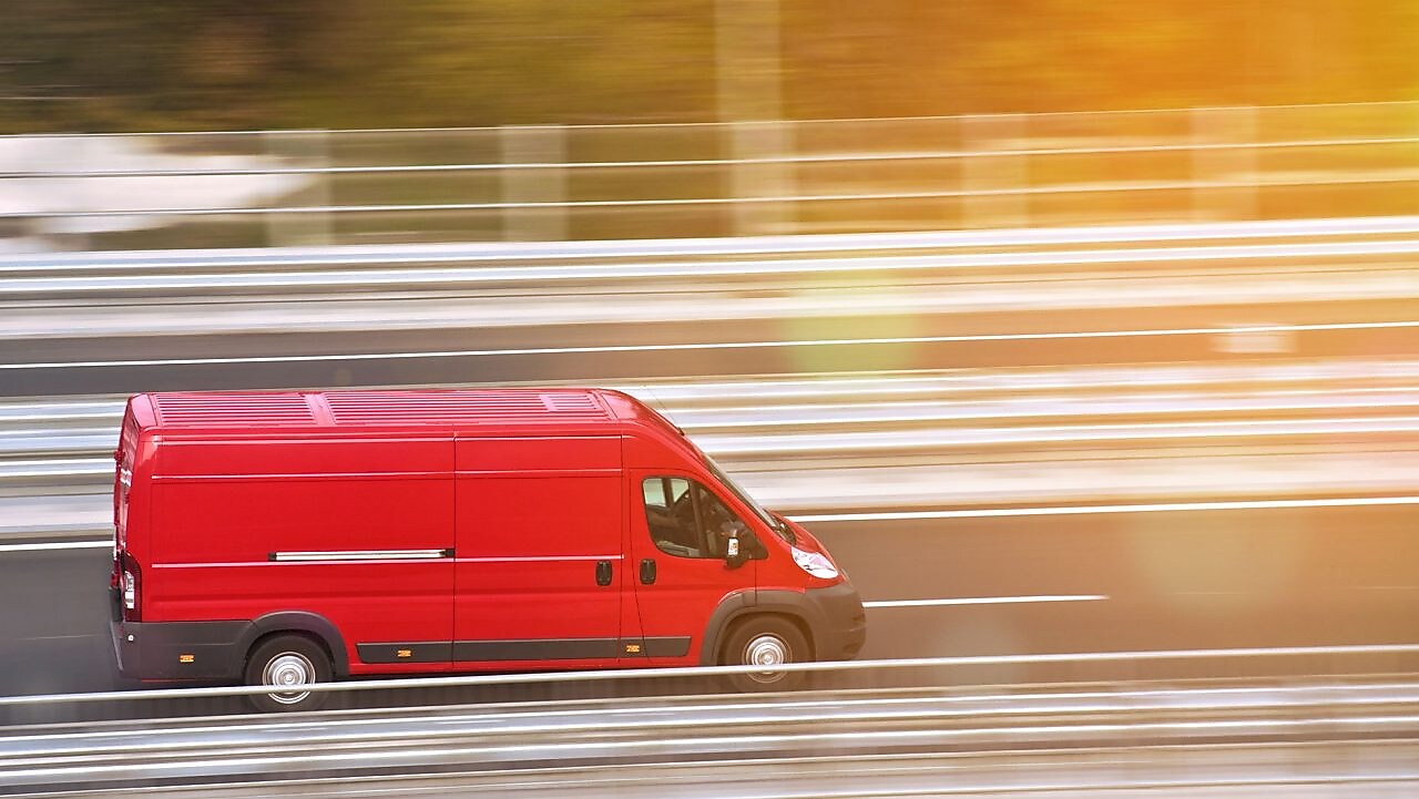 piros furgon az autópályán